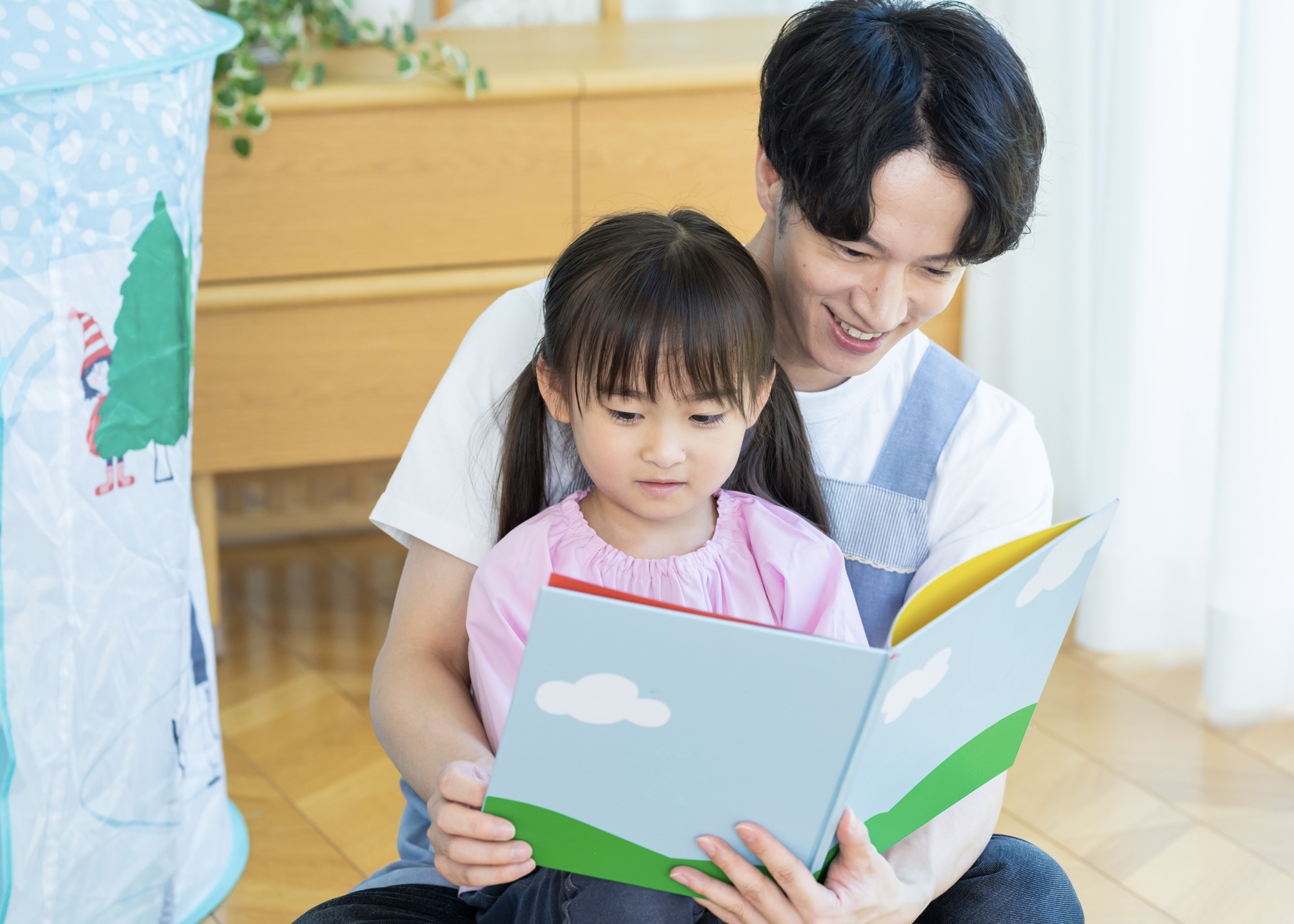 先生と園児が絵本を読んでいる様子