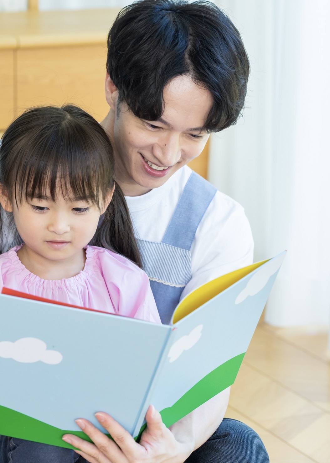 先生と園児が絵本を読んでいる様子